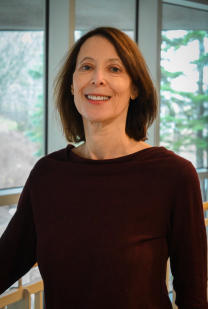 Woman with dark hair in front of window
