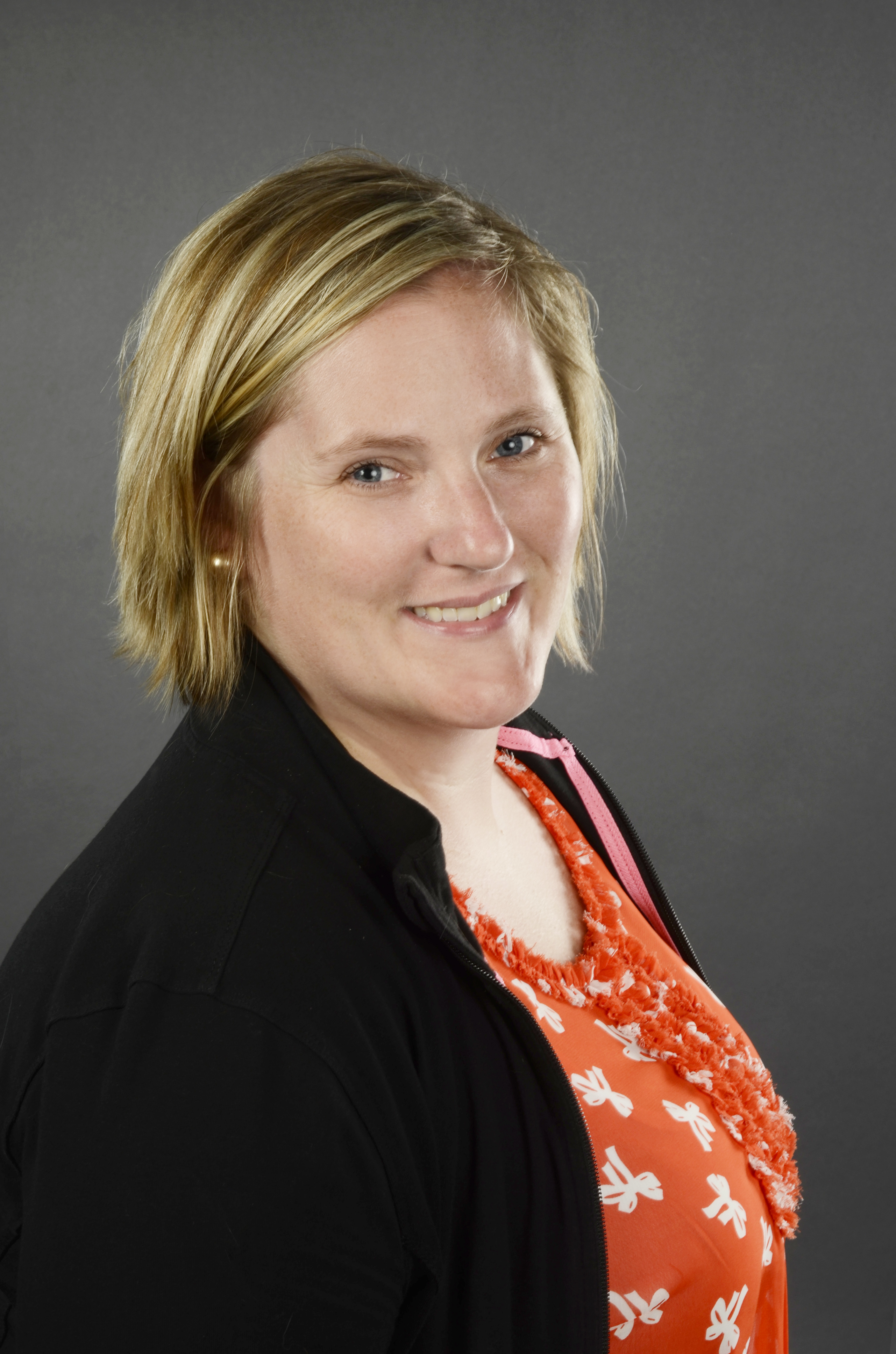 Woman with short blonde hair and an orange shirt