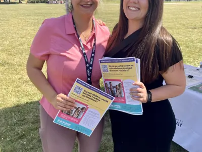 Two-women-holding-posters-in-the-park.png
